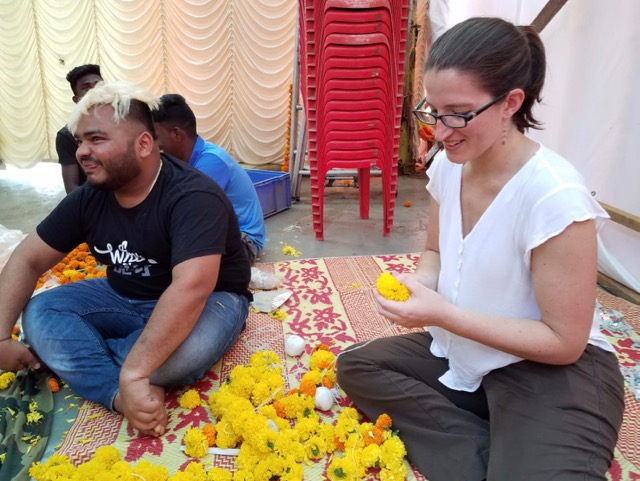 Stringing flowers while visiting India by cruise ship. 