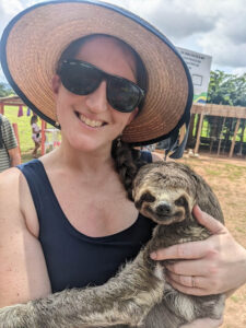 woman holding sloth in Brazil while on a cruise on the Amazon River